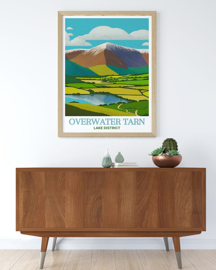 Lake District travel poster showcasing the serene waters of Overwater Tarn and the majestic Skiddaw fells. This print brings the charm of Cumbrias natural beauty into your space, perfect for decorating living rooms, offices, or bedrooms. An ideal gift for nature lovers.