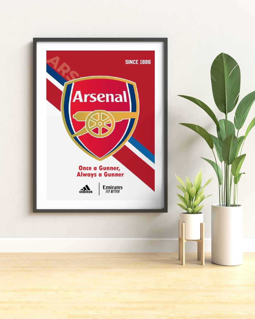 Modern sports home styling print featuring the historic red Arsenal crest with gold cannon wheel details, styled with clean graphic lines on museum-grade paper inside a sleek black wood frame.