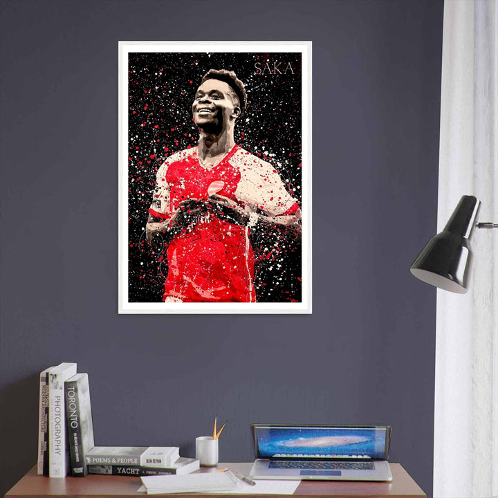 Arsenal FC wall art print of Bukayo Saka, rendered in a striking red, white, and black splatter-art style that captures the energy of North London&