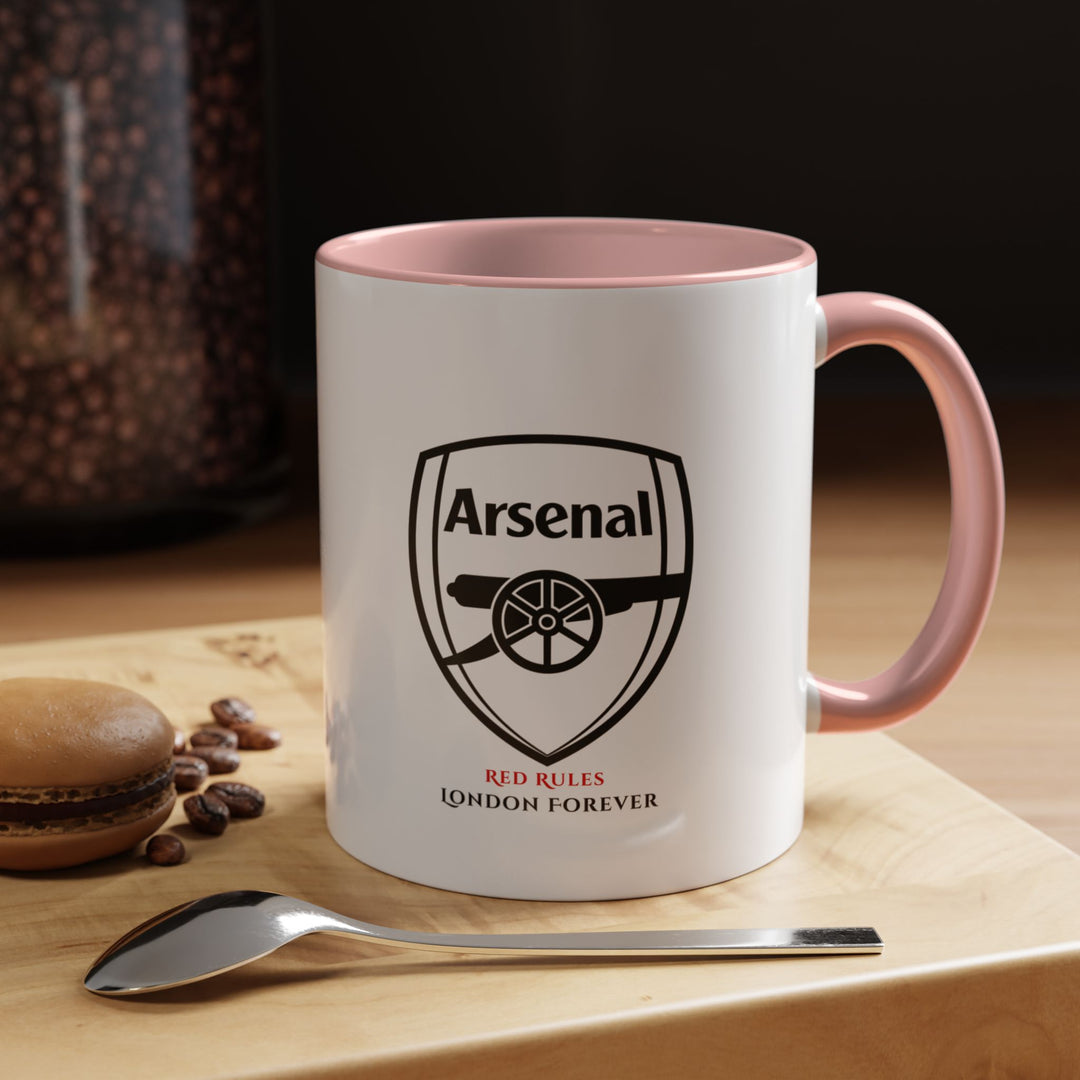 Pink Arsenal FC mug showcasing the official club crest on a glossy ceramic surface. Fits coffee, tea, and hot drinks. Ideal for fans who enjoy expressive colours and unique supporter merchandise. Works well for home or office use, gifting, and decoration. Created with care by Map Your Dreams.