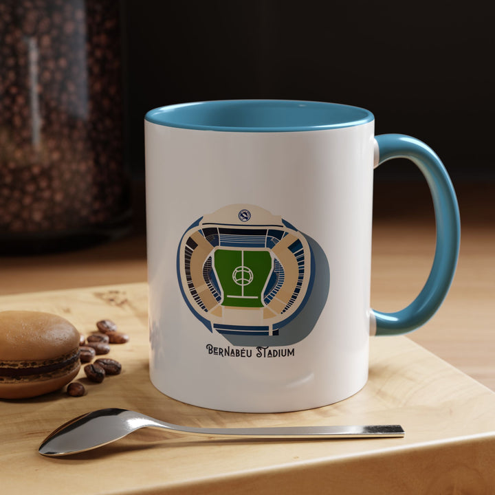 Santiago Bernabéu stadium inspired Real Madrid mug in blue. Features visual elements reflecting the stadium’s distinctive exterior and match-day feel, ideal for supporters who love the legacy and identity of the venue. A thoughtful fan gift and everyday drinkware piece that brings the spirit of Real Madrid into office desks, home kitchens, study setups, or match day viewing spaces.