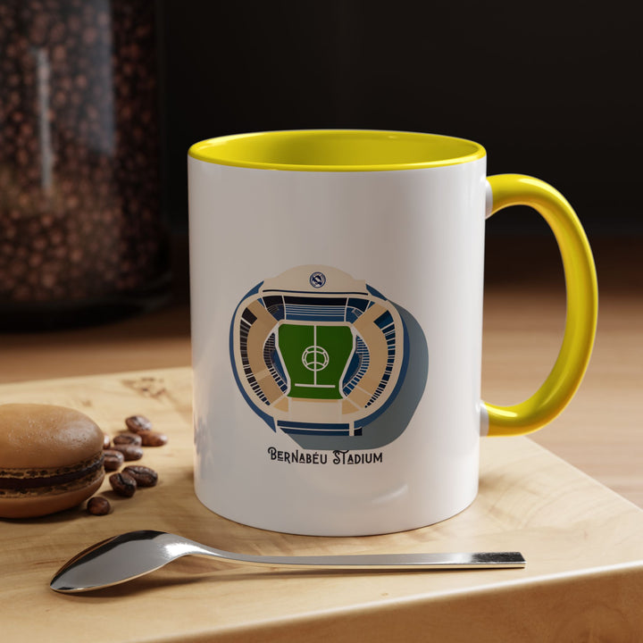Santiago Bernabéu stadium coffee and tea mug in bright yellow. The artwork captures the energy and excitement surrounding Real Madrid’s home ground, making it a vibrant choice for supporters who love bold, expressive colors. Ideal for gifting, daily use, or adding character to a Real Madrid supporter’s display shelf, kitchen, or match day ritual setup.