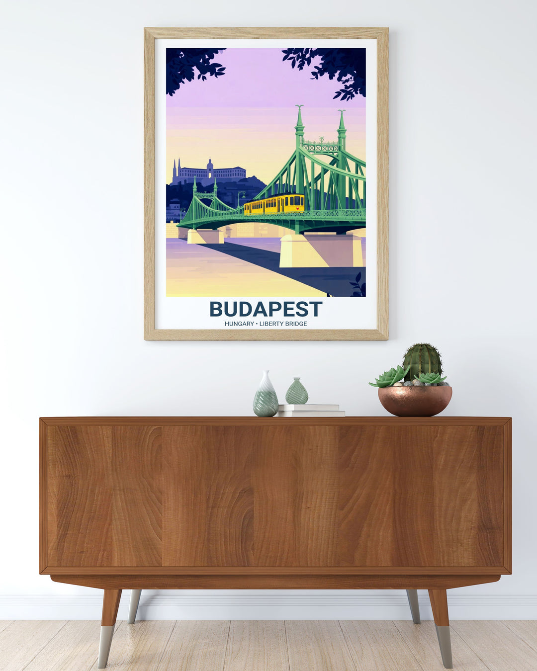 Wide perspective of the Liberty Bridge in Budapest. The composition uses a pastel palette of mint, lavender, and amber, showing a vintage tram moving toward the Buda side.