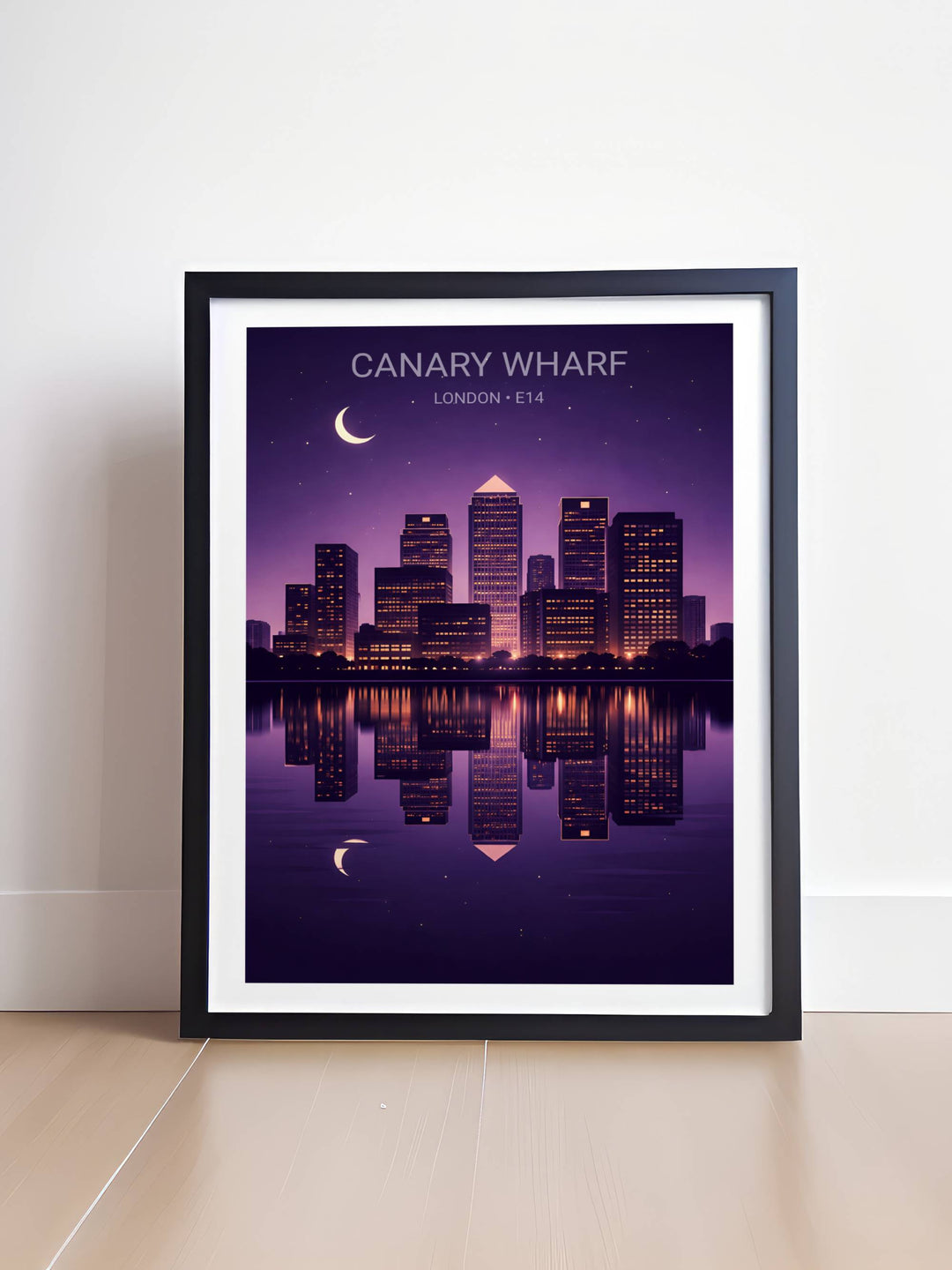 High-quality wall art print of Canary Wharf E14 at night with iconic towers like One Canada Square lit against a dark blue sky with a glowing crescent moon and reflections in the River Thames.