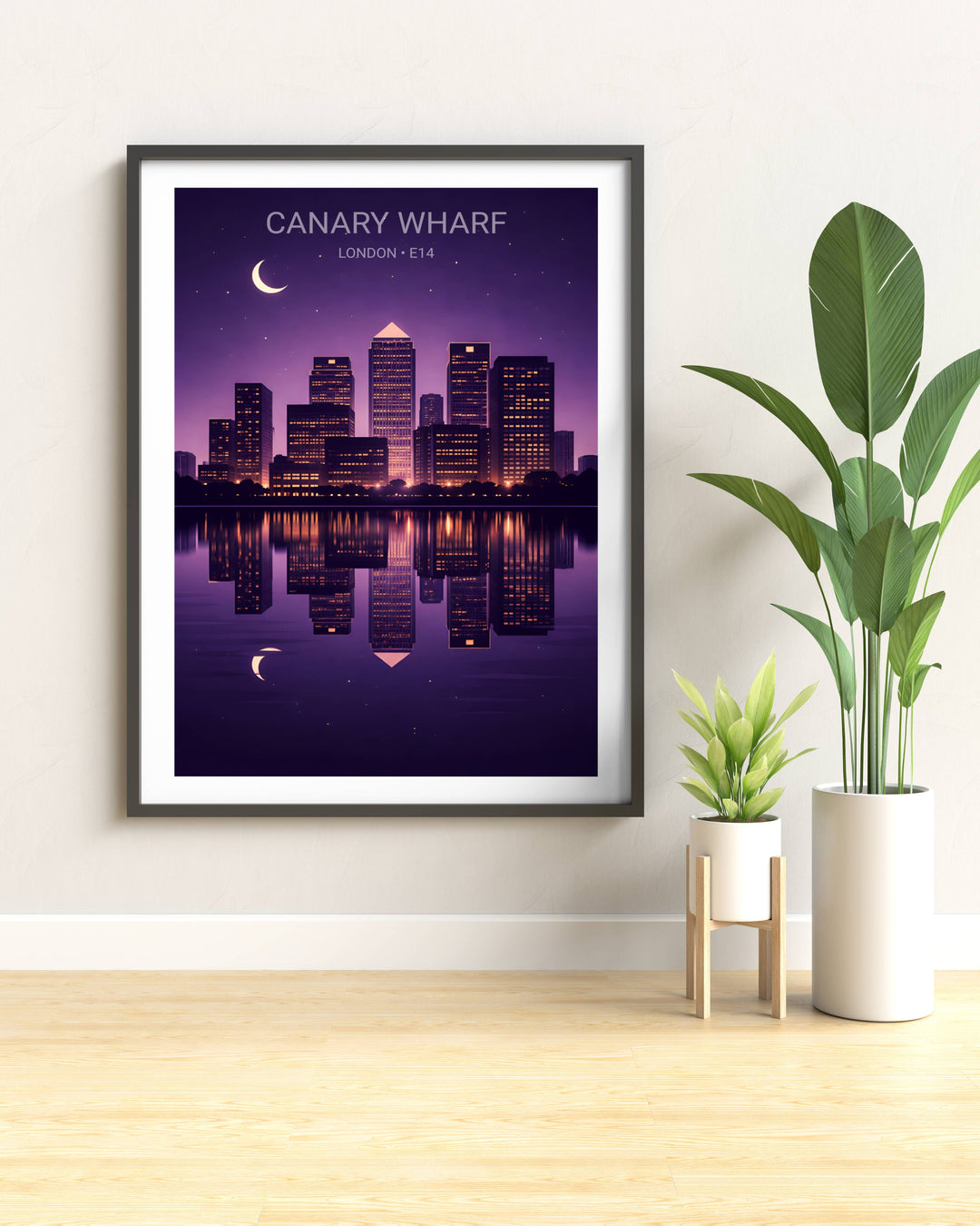 Framed artwork of Canary Wharf, London on a wall with plants.