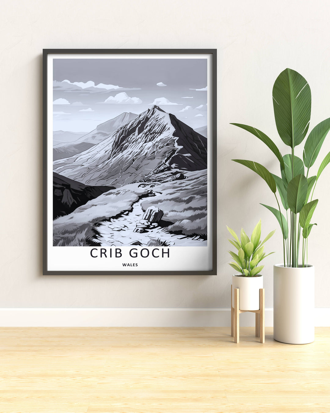 An evocative monochrome alpine print of the peak of Crib Goch in Wales featuring rich charcoal grey tones and dramatic dark shadows, available to purchase as a canvas print or a premium bronze frame.