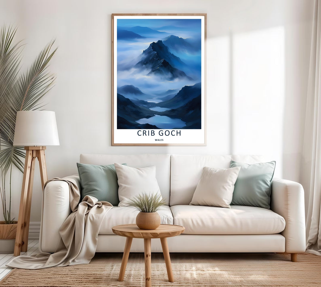 A colorful travel poster design of the scenic misty Crib Goch mountain ridge, available in a variety of presentation formats including unframed prints, canvas wall art, and framed finishes. The print highlights quiet lakes below a cloudy peak.