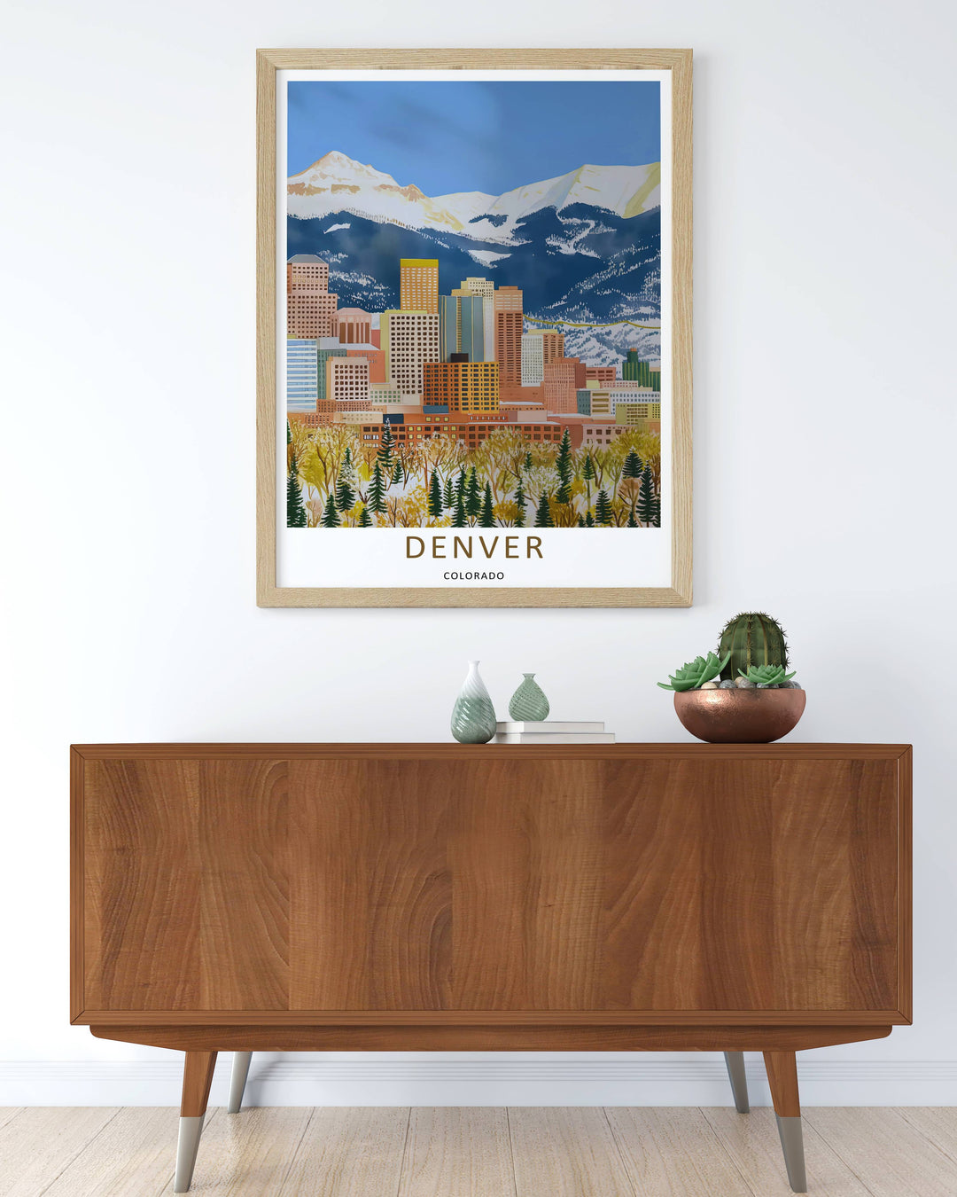 Denver skyline print showing sharp geometric building facades in front of majestic white alpine peaks. High-quality wall decor available in versatile framed, canvas, and unframed print options.