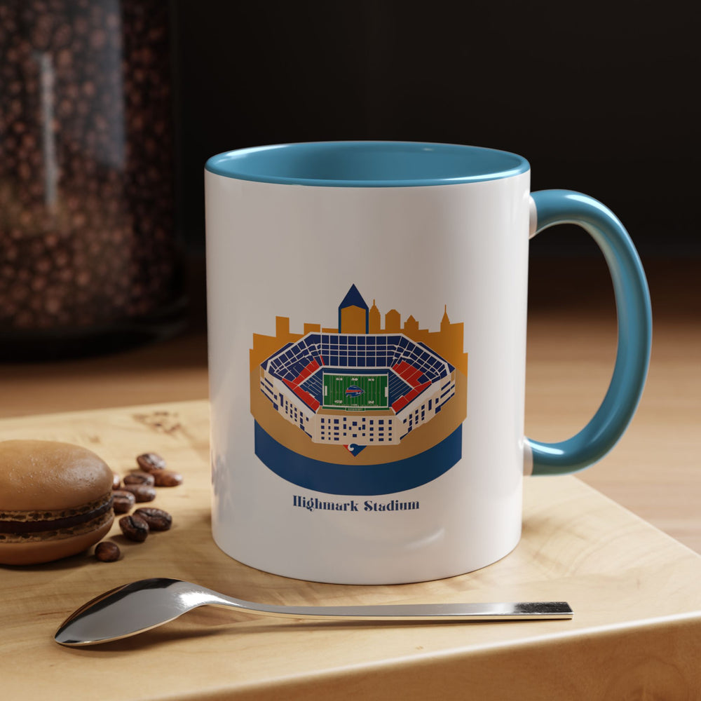 Royal Blue Highmark Stadium Mug featuring a crisp stadium illustration printed across the exterior, positioned near sports memorabilia to create a cohesive fan atmosphere. The bold blue ceramic perfectly matches Buffalo team identity, making this mug not only functional drinkware but also a meaningful display piece for collectors and loyal supporters.