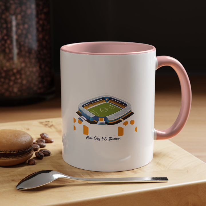 A lively pink Hull City FC stadium mug featuring a carefully drawn MKM Stadium design. Photographed in soft lighting to highlight its playful color and thoughtful detail, appealing to fans who appreciate a cheerful, personal touch in their club memorabilia while still honoring The Tigers and their home stadium.