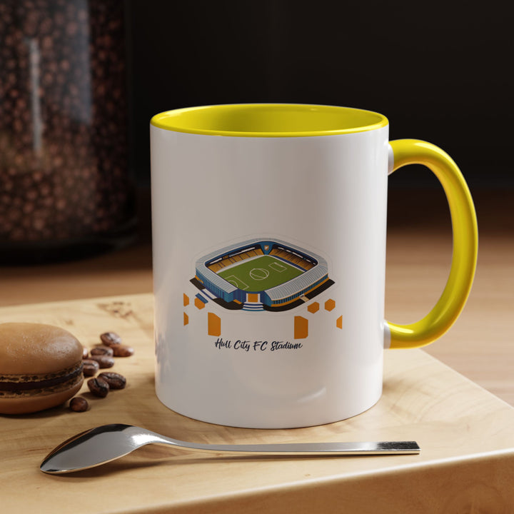 A vibrant yellow Hull City FC MKM Stadium mug with striking stadium artwork that stands out against the bright ceramic. Displayed in a sunny morning coffee moment, evoking energy, optimism, and match-day excitement — a perfect everyday reminder of chanting with fellow supporters at The Tigers’ home ground.