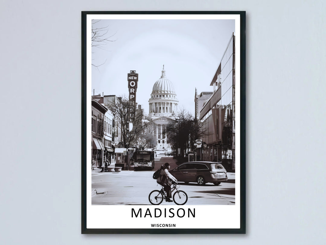 A beautiful Madison Wisconsin State Street Capitol black and white art print highlighting an active bicyclist riding past the iconic Orpheum Theatre sign with the majestic white Capitol dome centered in the background.