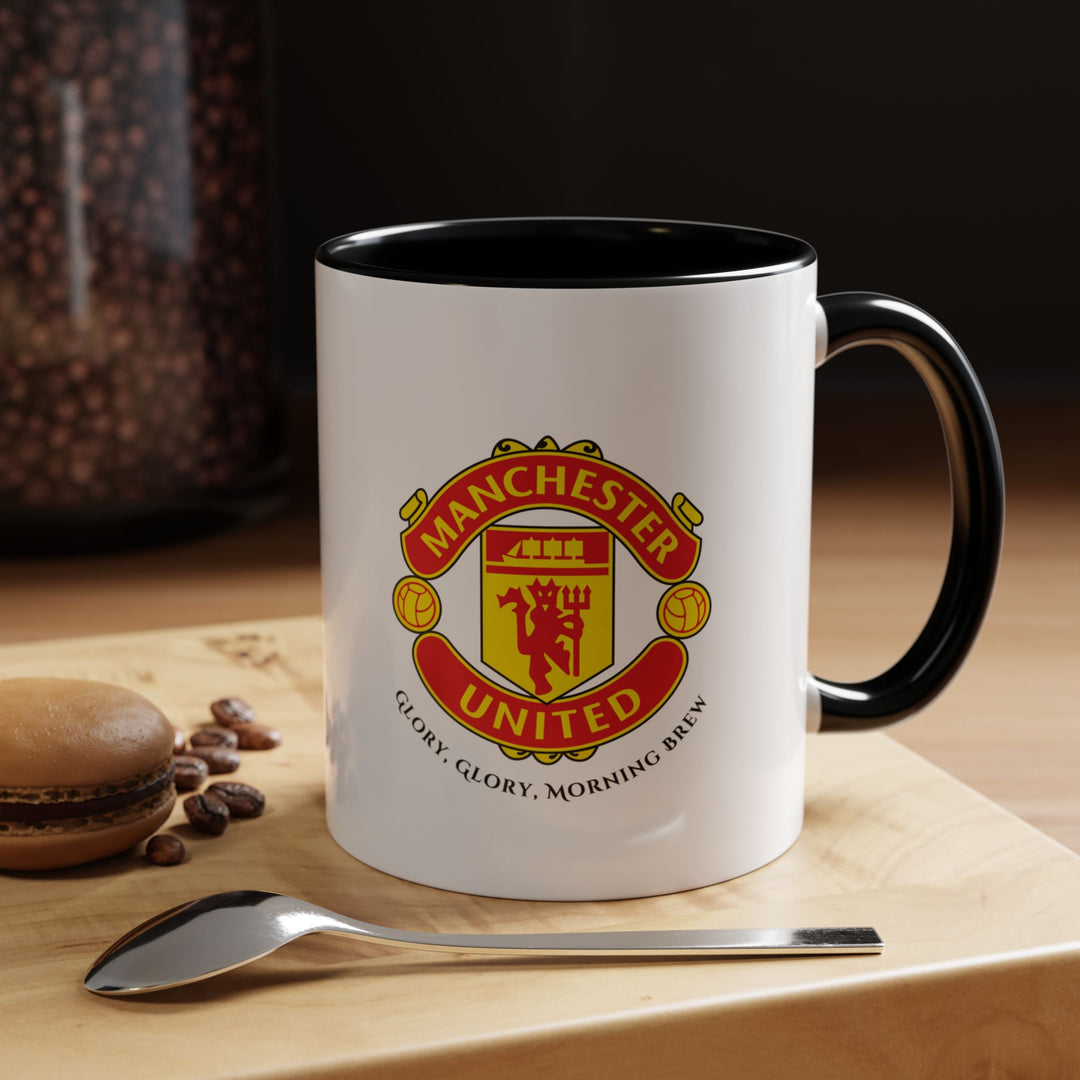 A sleek black Manchester United mug showcasing the official club crest. The bold black ceramic provides a modern aesthetic while highlighting the iconic Red Devils emblem. Perfect for coffee, tea, or hot chocolate at home, office, or for gifting to dedicated Manchester United fans, collectors, or football enthusiasts.