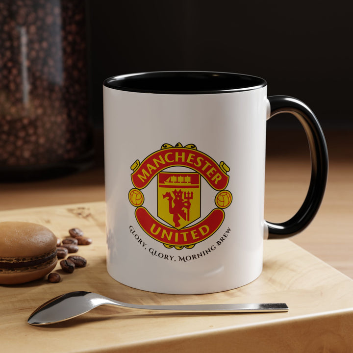 A sleek black Manchester United mug showcasing the official club crest. The bold black ceramic provides a modern aesthetic while highlighting the iconic Red Devils emblem. Perfect for coffee, tea, or hot chocolate at home, office, or for gifting to dedicated Manchester United fans, collectors, or football enthusiasts.