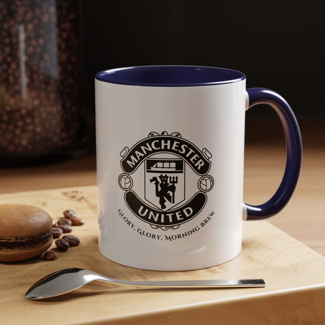 A navy blue Manchester United coffee mug displaying the official club crest in clear, bold detail. The deep navy tone adds sophistication while representing Red Devils pride. Perfect for coffee, tea, or hot chocolate, whether for daily use, office setups, or match-day traditions with fellow fans.