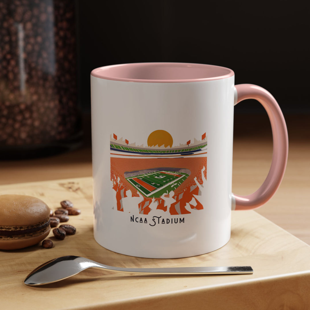 A pink NCAA Stadium mug with a printed illustration of a college football stadium, blending team spirit with a playful, modern look. Ideal for coffee, tea, or hot chocolate, the pink ceramic color adds a stylish touch to everyday routines. Perfect for fans who enjoy combining football pride with a unique fan aesthetic.
