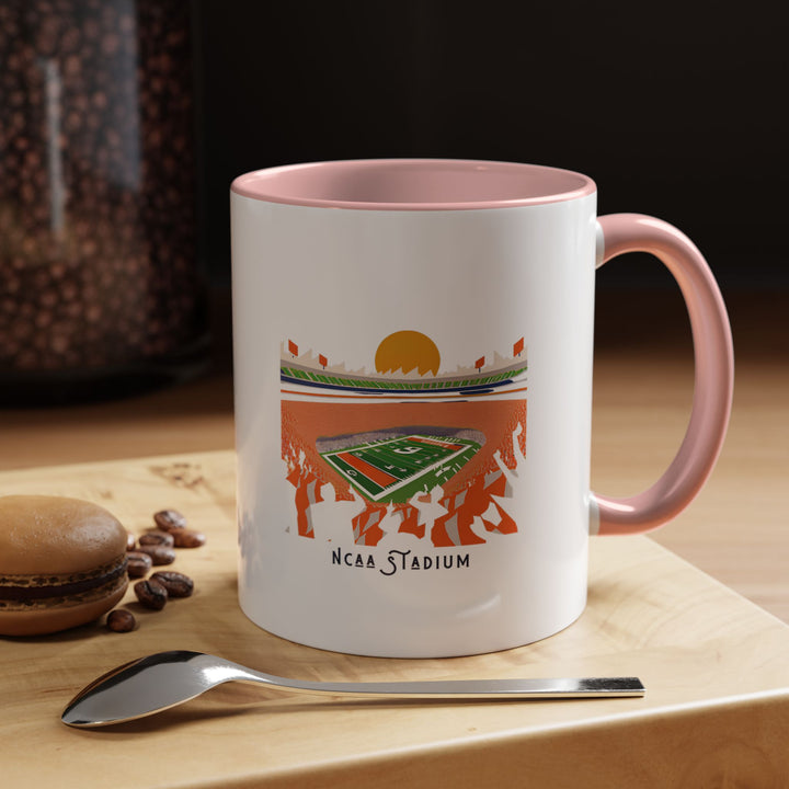 A pink NCAA Stadium mug with a printed illustration of a college football stadium, blending team spirit with a playful, modern look. Ideal for coffee, tea, or hot chocolate, the pink ceramic color adds a stylish touch to everyday routines. Perfect for fans who enjoy combining football pride with a unique fan aesthetic.