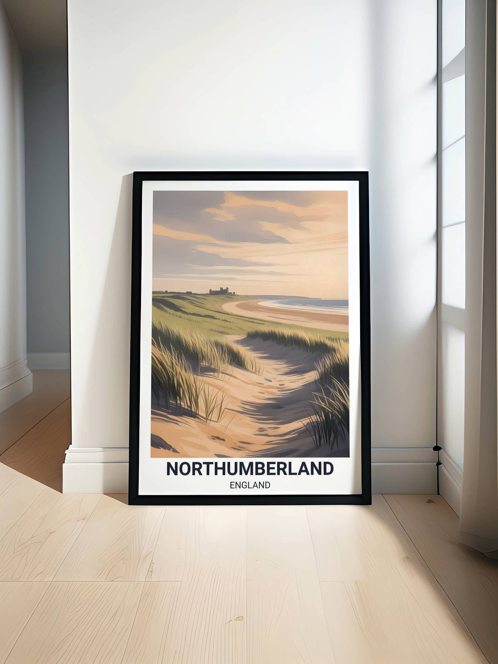 A large framed fine art print of the Northumberland coast, shown in a minimalist black wooden frame hanging on a clean gallery wall.