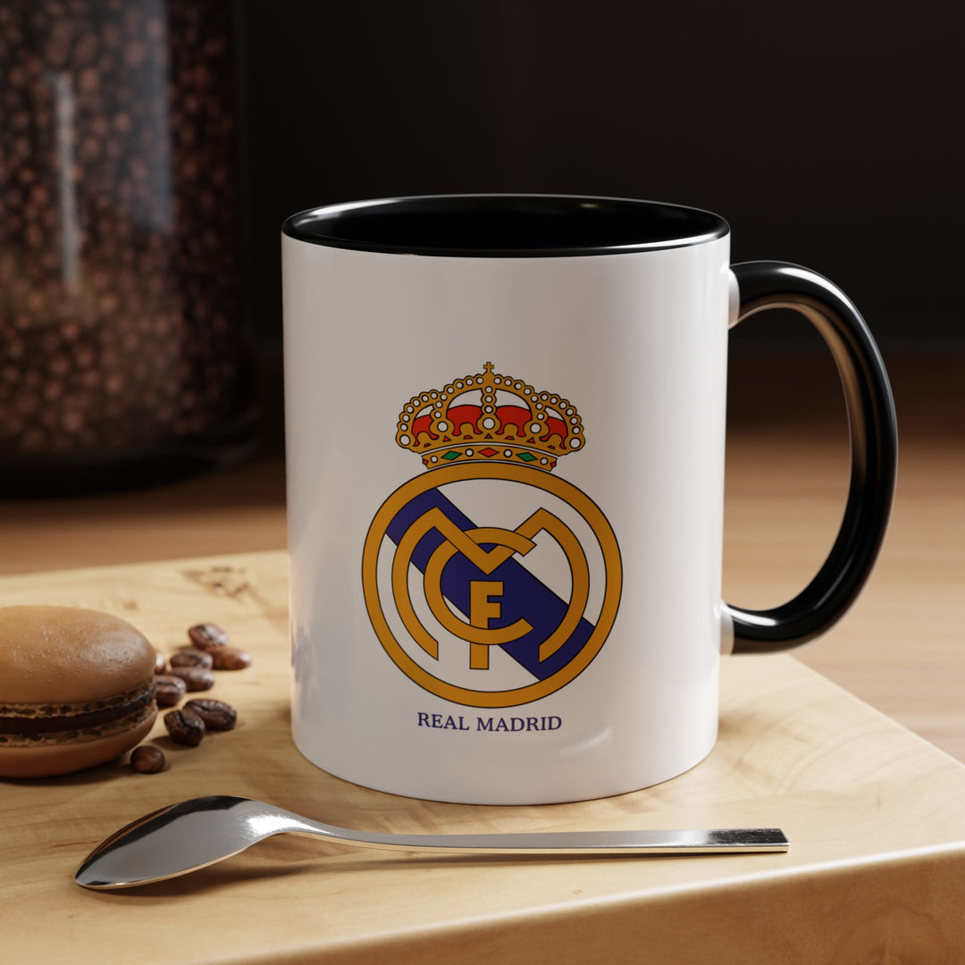 A sleek black Real Madrid FC mug featuring the club emblem, crafted from durable ceramic. Perfect for daily coffee, tea, or hot chocolate, it doubles as a stylish display piece or gift. Its subtle black design lets supporters show off their loyalty to Los Blancos in a modern, minimalist way.