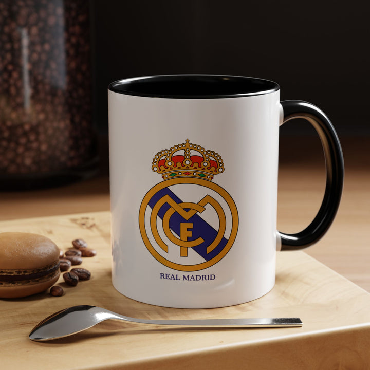 A sleek black Real Madrid FC mug featuring the club emblem, crafted from durable ceramic. Perfect for daily coffee, tea, or hot chocolate, it doubles as a stylish display piece or gift. Its subtle black design lets supporters show off their loyalty to Los Blancos in a modern, minimalist way.