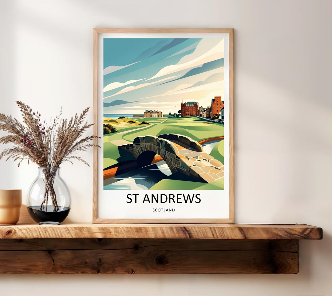 Framed golf course wall print depicting the legendary St Andrews links in Scotland, highlighted by the rustic stone arch of the Swilcan Bridge in the foreground and a panoramic view of the grand clubhouse architecture under soft sweeping clouds
