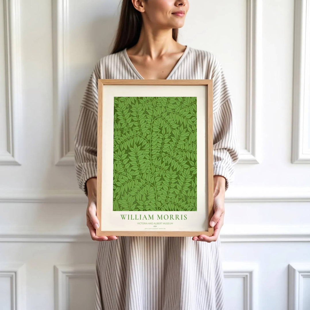 Decorative wall art print of William Morris Ash green leaf poster set against a clean cream margin, bringing timeless vintage British botanical elegance into home interior spaces.