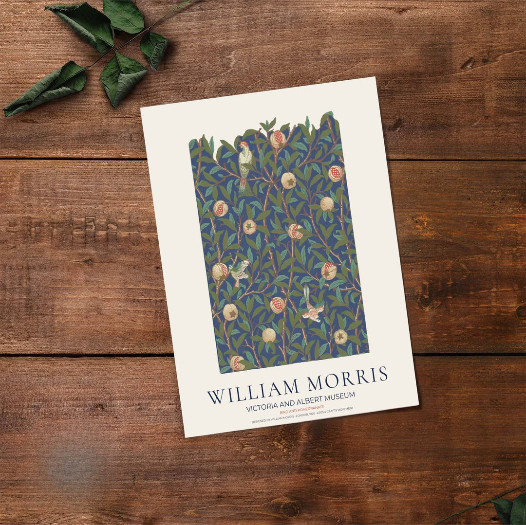 Decorative artwork print of William Morris Bird and Pomegranate featuring dense leaf background fills, terracotta fruit highlights, and a clean cream border suitable for luxury interior styling and wall displays.