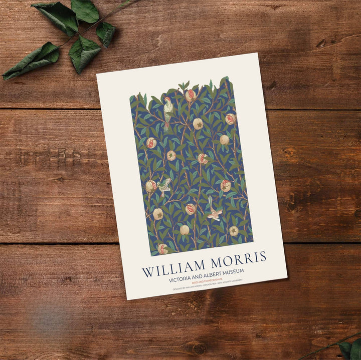Decorative artwork print of William Morris Bird and Pomegranate featuring dense leaf background fills, terracotta fruit highlights, and a clean cream border suitable for luxury interior styling and wall displays.