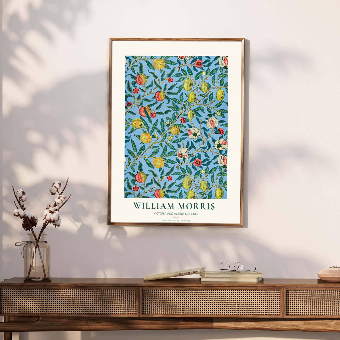 Victorian heritage wallpaper design by William Morris showing dense foliage, fruit tendrils, and a soft cream border with Victoria and Albert Museum text.