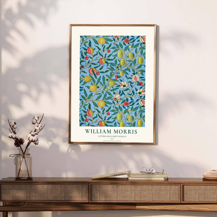 Victorian heritage wallpaper design by William Morris showing dense foliage, fruit tendrils, and a soft cream border with Victoria and Albert Museum text.