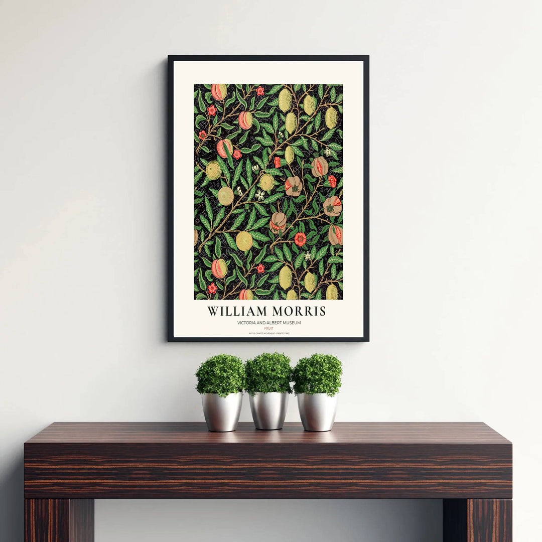 Elegant William Morris heritage wallpaper reproduction showing dense foliage and fruit tendrils framed by a clean cream exhibition margin.