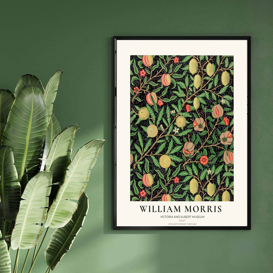 Rich green leaves intertwined with yellow citrus and coral red pomegranates in a restored vintage William Morris dark black exhibition print.