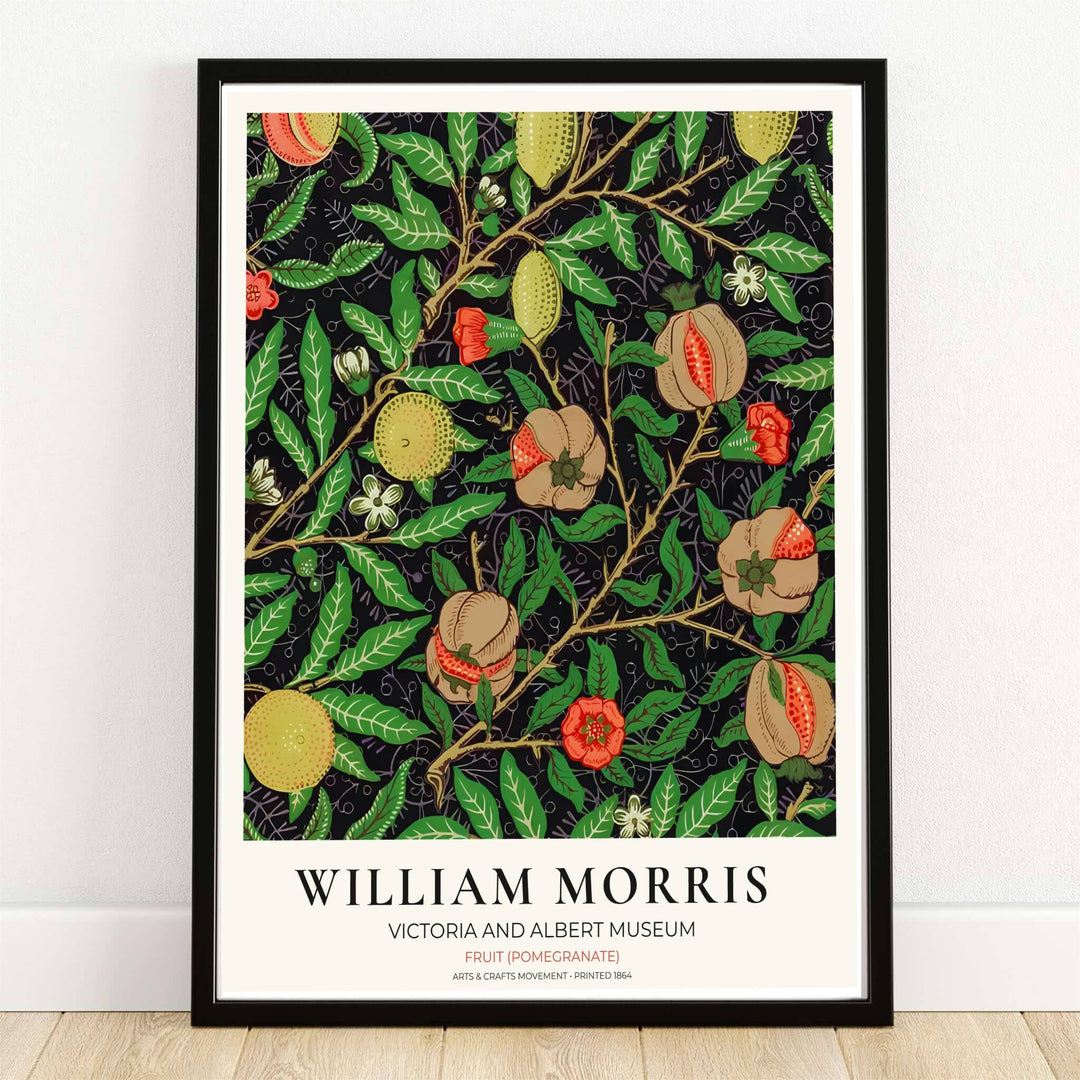 Ripe cut pomegranates, lemons, and peaches on a dark background in a classic William Morris Fruit Pomegranate botanical wall print.