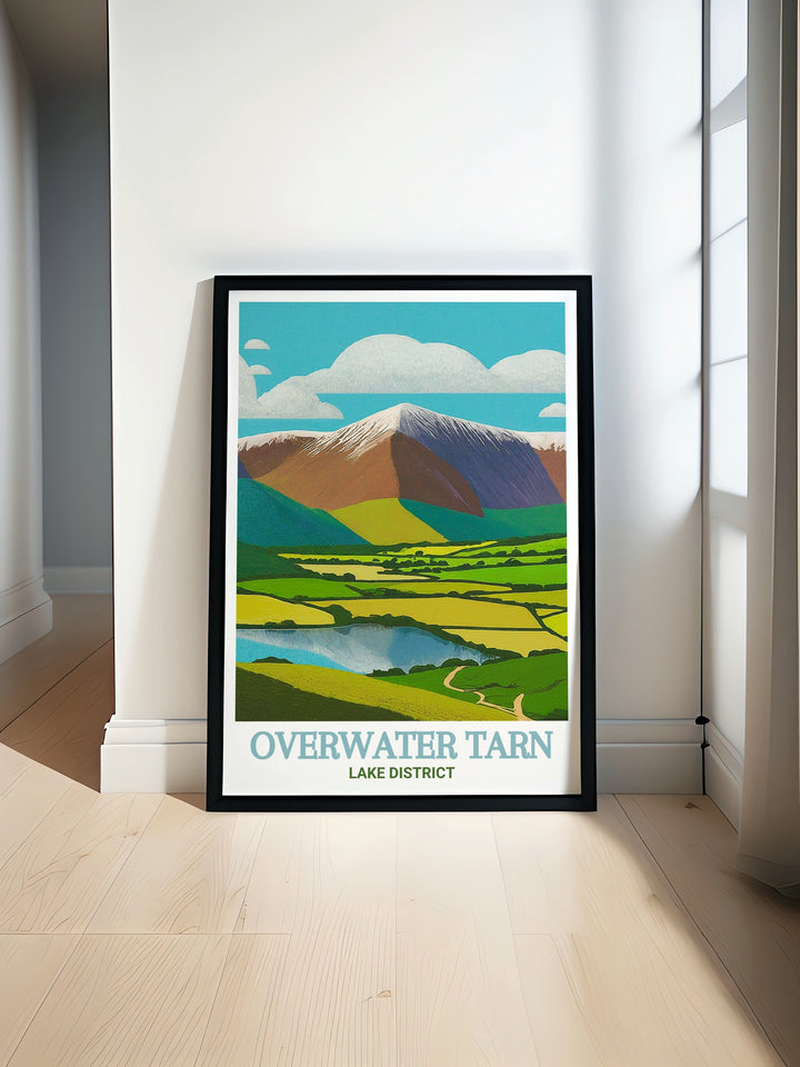 Skiddaw travel print celebrating the natural splendor of the Lake District. This artwork features the dramatic peaks of Skiddaw and the serene waters of Overwater Tarn, creating a captivating piece for your home decor. A thoughtful gift for friends and family.