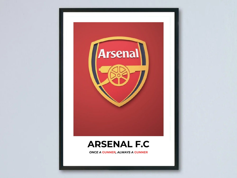 Minimalist Arsenal football wall art print showcasing the official club badge, bold black typography, and a clean white border inside a sleek black gallery frame hanging on a grey wall