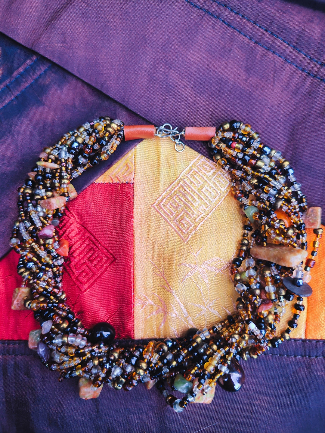 Handcrafted multi-strand choker necklace with natural stone chips, obsidian, agate, and glass seed beads in a layered statement design.