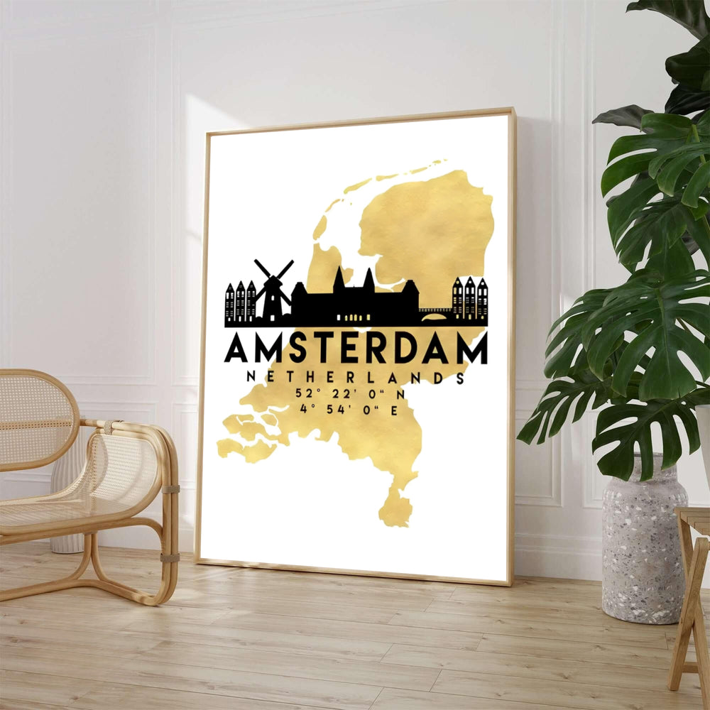 High-contrast luxury art print of the Netherlands map in metallic gold with an Amsterdam skyline silhouette including windmills and historic gables, offered by MapYourDreams where you can choose between an unframed paper poster, museum stretched canvas, or custom frame finishes for living rooms.