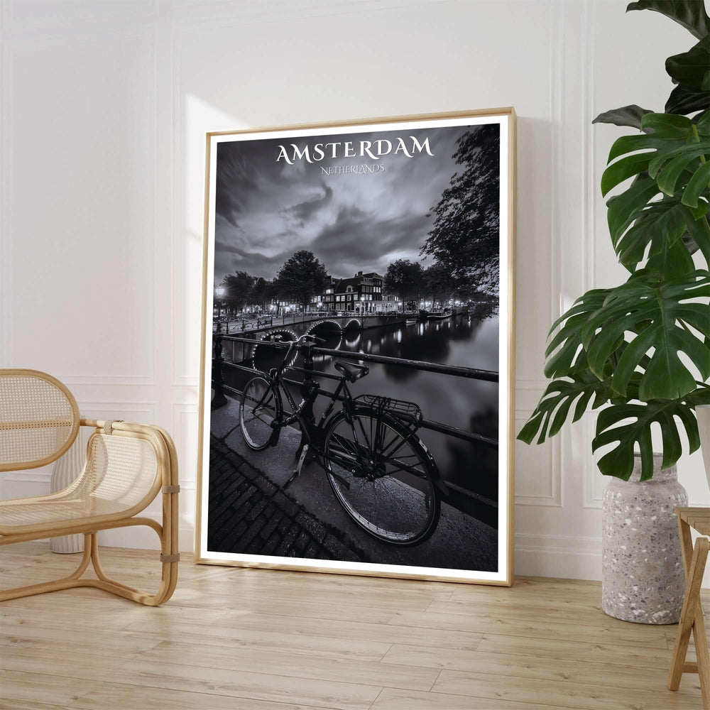 Dramatic monochrome cityscape print of a classic Dutch bicycle parked beside an Amsterdam canal bridge at night, available from MapYourDreams where customers can choose between unframed fine art posters, gallery wrapped canvas decor, and custom frame options for sophisticated living room walls.