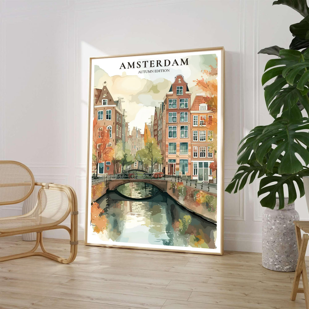Warm watercolor art print of an Amsterdam canal bridge surrounded by amber autumn trees and terracotta buildings, available from MapYourDreams where shoppers can select between unframed fine art posters, gallery wrapped canvas prints, and custom framed decor options for home offices.