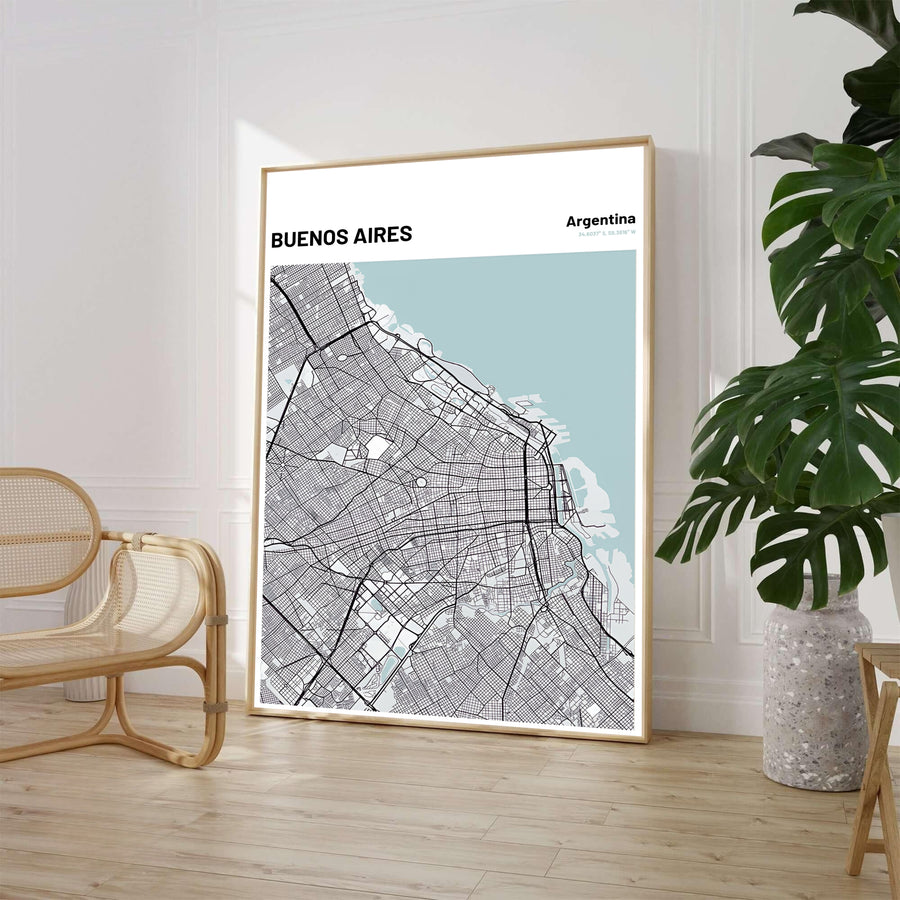 Minimalist city grid wall decor of Buenos Aires featuring charcoal road networks and light blue coastal water accents. Available through MapYourDreams, customers can select from fine art paper, handcrafted timber frames, or stretched canvas options.