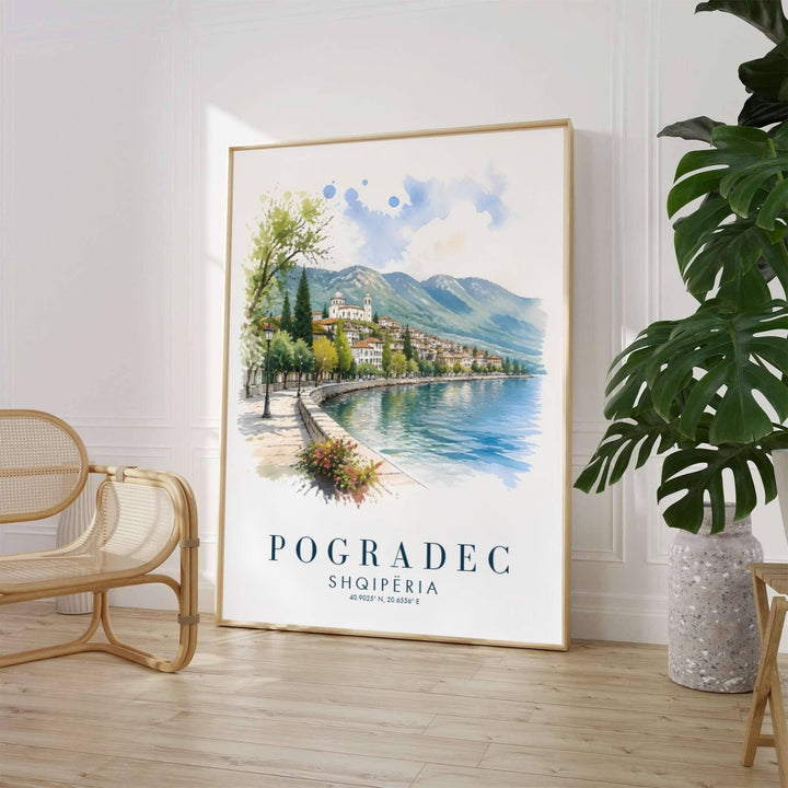 A fluid fine art watercolor painting depicts the charming lakeside resort town of Pogradec with rolling green hills and gentle blue water ripples. Customers can select from unframed archival paper stock, custom wood frames, or gallery canvas wraps to suit their home decor preferences.