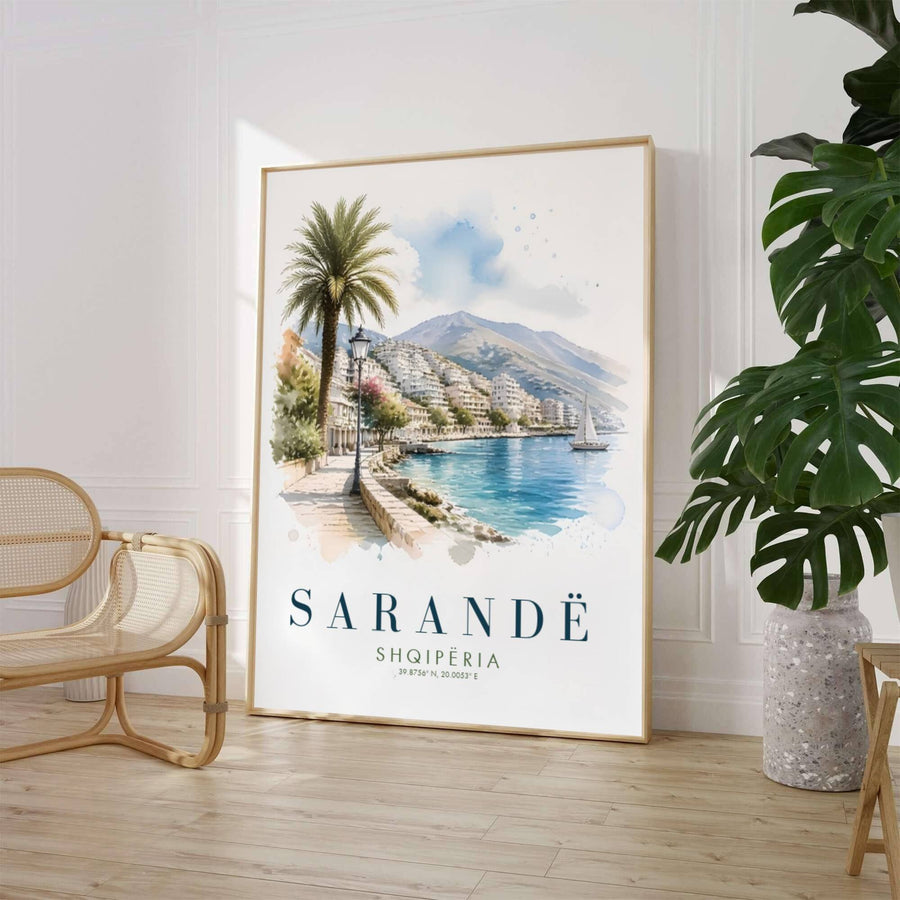 A fluid fine art watercolor painting depicts the vibrant coastal resort town of Sarandë with tiered white hillside buildings and a lone sailboat. Customers can select from unframed archival paper stock, custom wood frames, or gallery canvas wraps to suit their home interior style preferences.