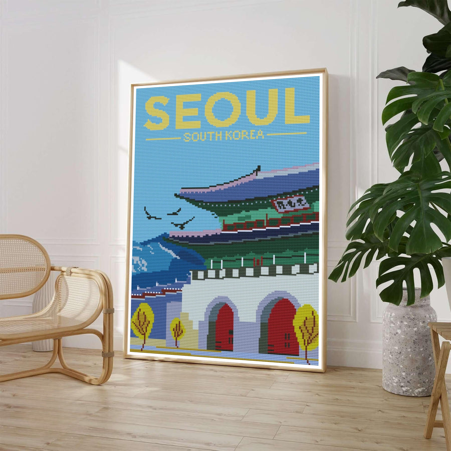Retro needlepoint style poster illustrating Gwanghwamun Gate at Gyeongbokgung Palace in Seoul, South Korea, set against a bright sky-blue woven background with bold yellow typography reading SEOUL SOUTH KOREA. Offered by MapYourDreams, this artwork is available in flexible options including unframed paper, custom wooden frames, and gallery canvas wraps.