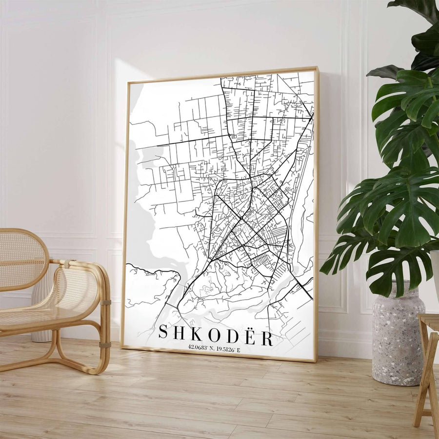A high-contrast monochrome street map highlights the road network of Shkodër, set against a clean white background with elegant serif typography. Select from flexible display choices like unframed paper stock, custom frames in various wood finishes, or gallery canvas wraps.