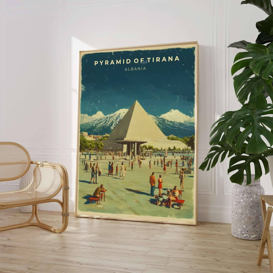 A distressed retro travel illustration captures the iconic Pyramid of Tirana framed by sunlit plaza paving stones and snow-dusted mountain ridges beneath a deep twilight sky. Customers can select from unframed archival paper stock, custom wood frames, or gallery canvas wraps to suit their home decor style.