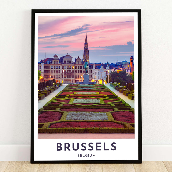 A breathtaking photographic travel poster capturing the manicured hedges of Mont des Arts garden at sunset in Brussels, Belgium, with the Town Hall spire piercing a pink sky. Offered by MapYourDreams, this artwork is available in flexible options including unframed paper, custom wooden frames, and gallery canvas wraps.