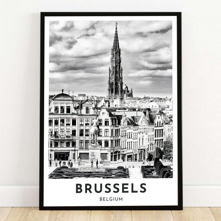 A dramatic black and white photography print showing the elevated view from Mont des Arts over the Gothic Town Hall spire in Brussels, Belgium. Offered by MapYourDreams, this artwork is available in flexible options including unframed paper, custom wooden frames, and gallery canvas wraps.