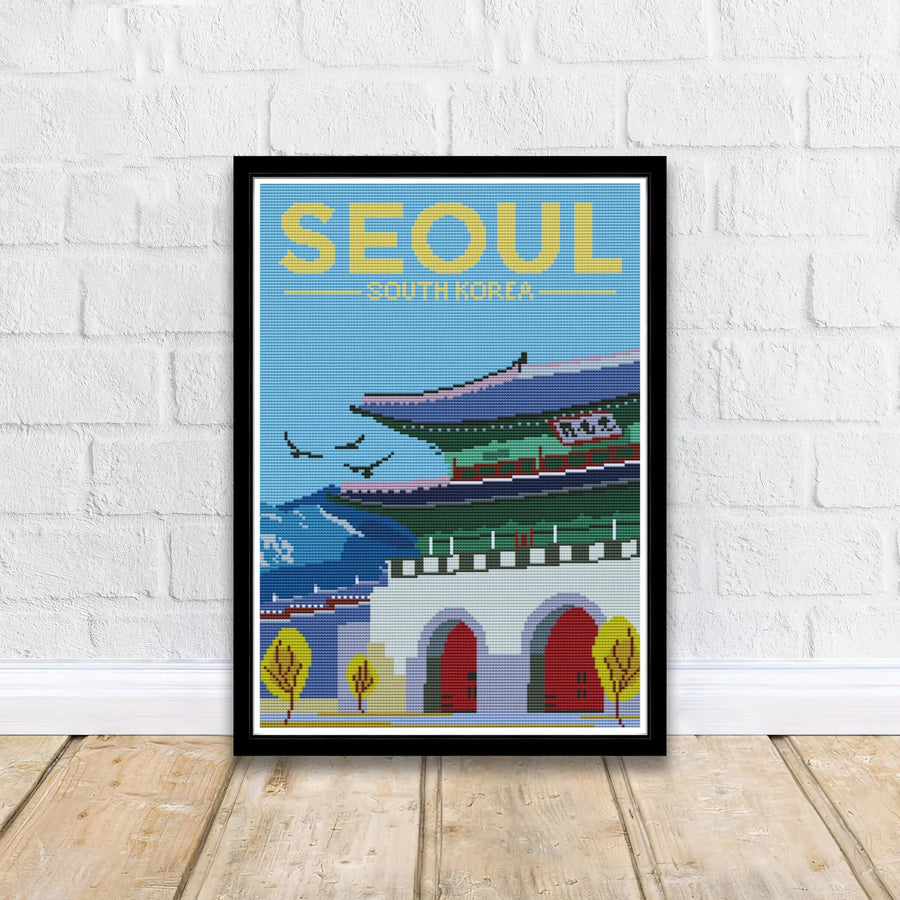 Vintage needlepoint travel print presenting Gwanghwamun Gate at Gyeongbokgung Palace in Seoul, South Korea, featuring dark red wooden doors, white fortress walls, and stylized yellow autumn foliage. Offered by MapYourDreams, this artwork is available in flexible options including unframed paper, custom wooden frames, and gallery canvas wraps.
