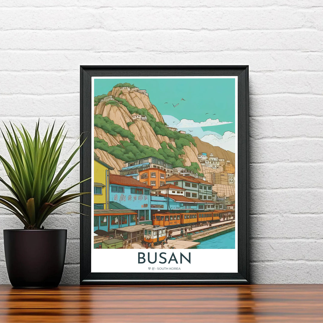 Charming Asian seaside village poster depicting Busan, South Korea, with terraced houses built along steep cliffs overlooking a tranquil blue bay and train tracks. Offered by MapYourDreams, this artwork is available in flexible options including unframed paper, custom wooden frames, and gallery canvas wraps.