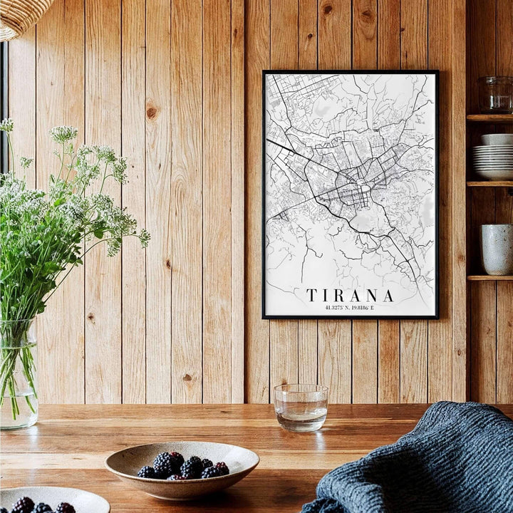 A sophisticated black and white geographical map of Tirana, Albania, framed by clean borders in a vertical portrait format. Available across multiple formats including unframed paper, tailored wooden frames, and gallery-wrapped canvas options.